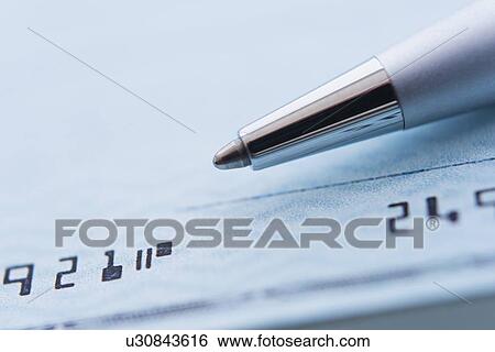 Stock Photograph - Detail of check with ballpoint pen, studio shot. Fotosearch
