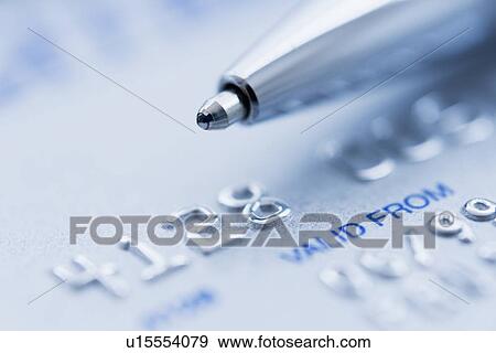 Stock Photo - Detail of credit card with ballpoint pen, studio shot. Fotosearch