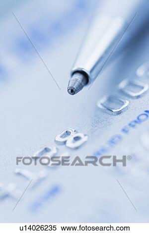 Stock Photography - Detail of credit card with ballpoint pen, studio shot. Fotosearch