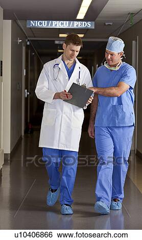 Stock Photograph - Doctor and surgeon walking in corridor. Fotosearch