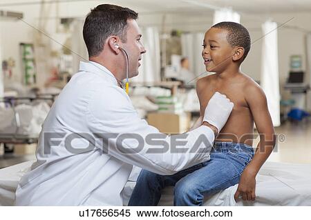 Doctor examining boy (4-5) in hospital View Large Photo Image Stock Photography - Doctor examining boy (4-5) in hospital. Fotosearch