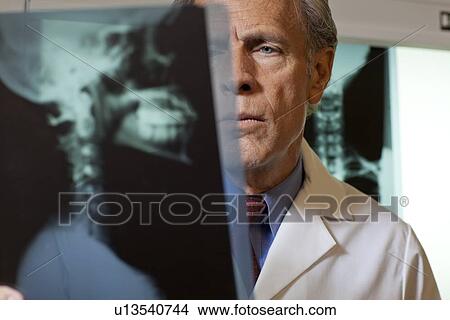 Doctor looking at x-ray View Large Photo Image Picture - Doctor looking at x-ray. Fotosearch