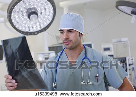 Doctor looking at x-ray View Large Photo Image Stock Photo - Doctor looking at x-ray. Fotosearch