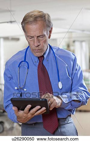 Stock Image - Doctor using digital tablet in hospital. Fotosearch