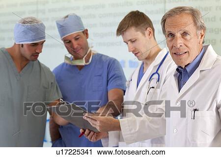 Stock Image - Doctors and surgeons discussing on medical record. Fotosearch