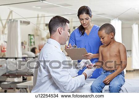Picture - Doctors applying bandage on boy's (4-5) hand. Fotosearch