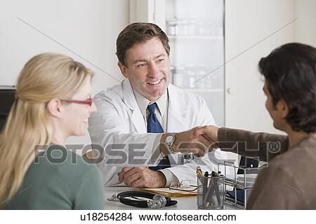 Doctors shaking hands in office View Large Photo Image Picture - Doctors shaking hands in office. Fotosearch
