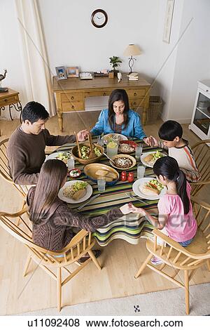 Family with three children (8-9, 10-11) praying at table View Large Photo Image Stock Photo - Family with three children (8-9, 10-11) praying at table. Fotosearch