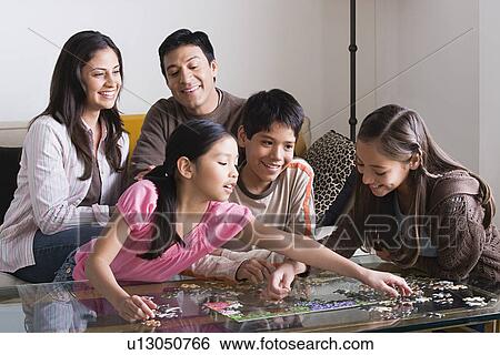 Family with three children (8-9, 10-11) playing with puzzle View Large Photo Image Stock Photograph - Family with three children (8-9, 10-11) playing with puzzle. Fotosearch
