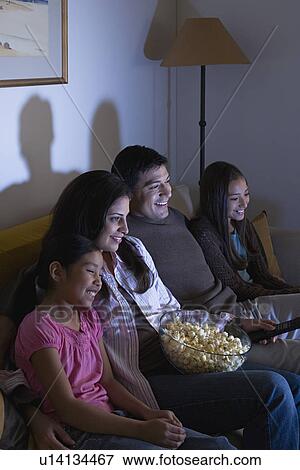 Family with two children (8-9, 10-11) watching tv on sofa View Large Photo Image Stock Photo - Family with two children (8-9, 10-11) watching tv on sofa. Fotosearch