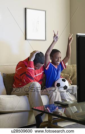 Father and Son (12-13) watching sports on tv View Large Photo Image Stock Image - Father and Son (12-13) watching sports on tv. Fotosearch