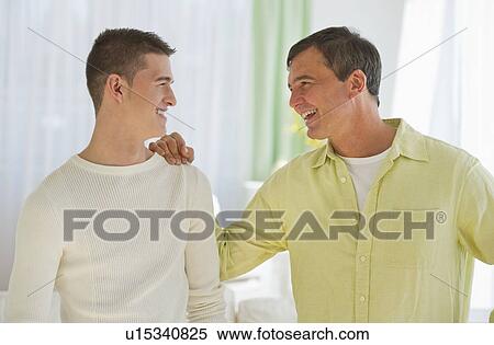 Stock Photography - Father and son (16-17) talking. Fotosearch