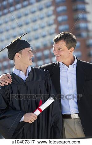 Father with teenage sun (16-17) at graduation ceremony View Large Photo Image Stock Photo - Father with teenage sun (16-17) at graduation ceremony. Fotosearch