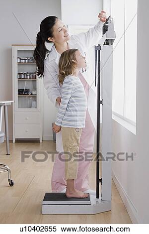 Female doctor measuring girl's (4-5) weight View Large Photo Image Stock Photography - Female doctor measuring girl's (4-5) weight. Fotosearch