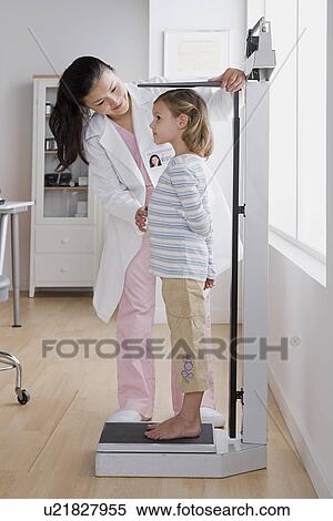 Female doctor measuring small girl (4-5) View Large Photo Image Stock Photography - Female doctor measuring small girl (4-5). Fotosearch