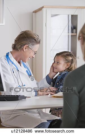Female doctor stroking small girl (4-5) View Large Photo Image Stock Photograph - Female doctor stroking small girl (4-5). Fotosearch