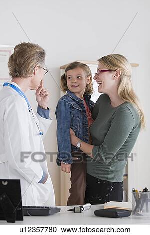 Female doctor talking to small girl (4-5) and her mother View Large Photo Image Stock Image - Female doctor talking to small girl (4-5) and her mother. Fotosearch