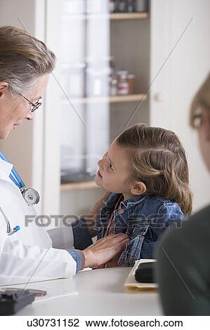 Female doctor talking to small girl (4-5) in her office View Large Photo Image Stock Image - Female doctor talking to small girl (4-5) in her office. Fotosearch