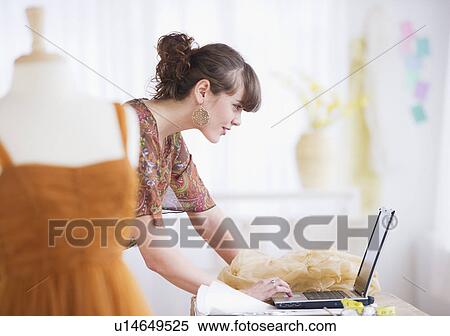 Stock Photography - Female fashion designer working in studio. Fotosearch