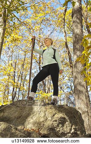 Female hiker resting on rock in forest View Large Photo Image Stock Photo - Female hiker resting on rock in forest. Fotosearch