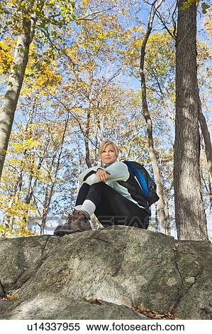 Female hiker resting on rock in forest View Large Photo Image Stock Photography - Female hiker resting on rock in forest. Fotosearch
