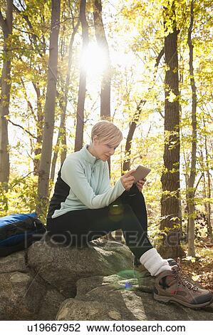 Female hiker using digital tablet in forest View Large Photo Image Stock Image - Female hiker using digital tablet in forest. Fotosearch