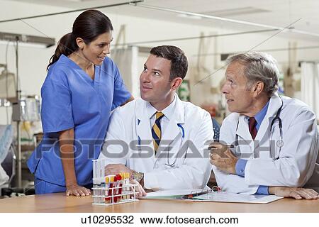 Female surgeon and two male doctors in hospital View Large Photo Image Stock Image - Female surgeon and two male doctors in hospital. Fotosearch