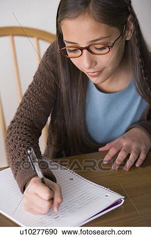 Stock Image - Girl (10-11) doing homework. Fotosearch