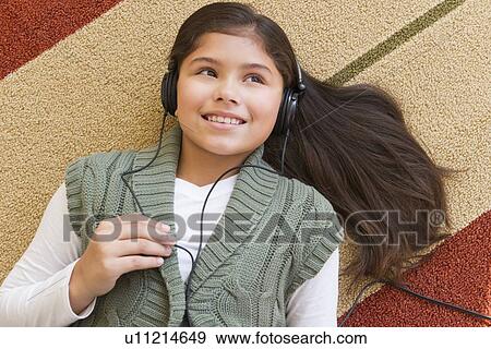 Stock Photo - Girl (10-11) listening music . Fotosearch