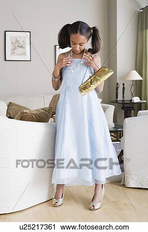 Girl (10-11) trying on elegant clothes View Large Photo Image Stock Image - Girl (10-11) trying on elegant clothes. Fotosearch