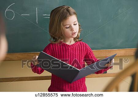 Stock Photography - Girl (6-7) having presentation in classroom. Fotosearch