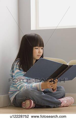 Girl (6-7) reading book in classroom View Large Photo Image Stock Image - Girl (6-7) reading book in classroom. Fotosearch