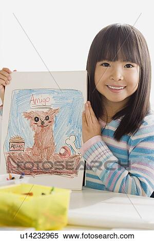 Stock Photography - Girl (6-7) showing her drawing. Fotosearch