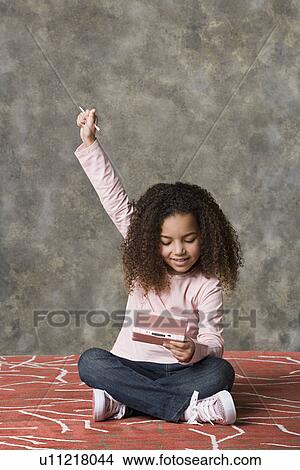 Picture - Girl (8-9) playing game, studio shot. Fotosearch