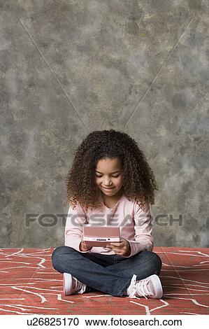 Girl (8-9) playing game, studio shot View Large Photo Image Stock Image - Girl (8-9) playing game, studio shot. Fotosearch