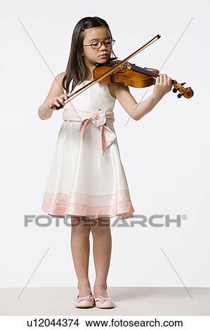 Girl (8-9) playing violin, studio shot View Large Photo Image Picture - Girl (8-9) playing violin, studio shot. Fotosearch
