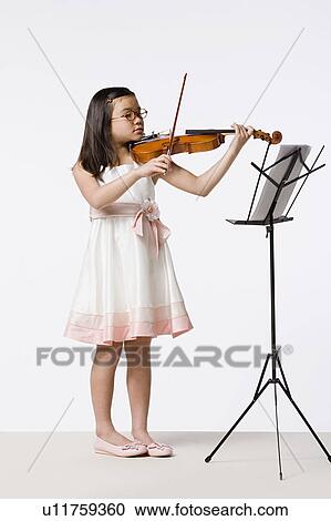 Girl (8-9) playing violin, studio shot View Large Photo Image Stock Image - Girl (8-9) playing violin, studio shot. Fotosearch