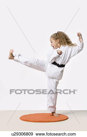 Girl (8-9) training martial arts, studio shot View Large Photo Image Stock Photo - Girl (8-9) training martial arts, studio shot. Fotosearch