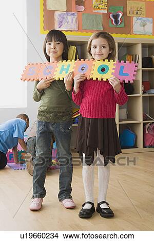 Picture - Girls (6-7) holding word 'school'. Fotosearch