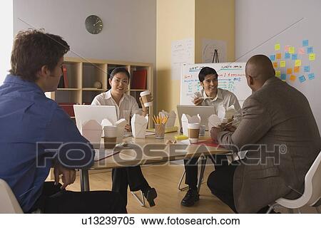 Stock Photography - Group of young businesspeople sharing lunch. Fotosearch