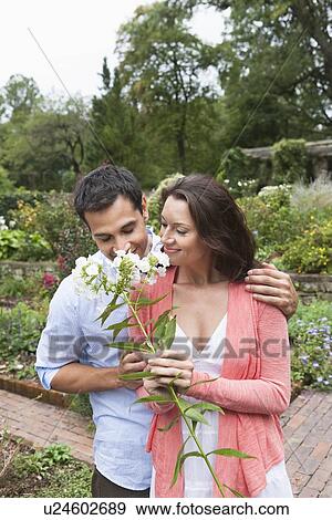 Happy couple smelling white flowers View Large Photo Image Stock Photo - Happy couple smelling white flowers. Fotosearch