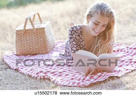 Happy teenage girl (16-17) reading book outdoors View Large Photo Image Stock Photo - Happy teenage girl (16-17) reading book outdoors. Fotosearch