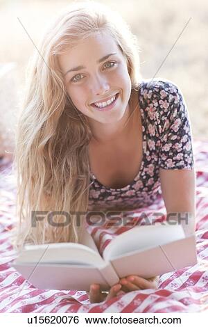Happy teenage girl (16-17) reading book outdoors View Large Photo Image Stock Photograph - Happy teenage girl (16-17) reading book outdoors. Fotosearch