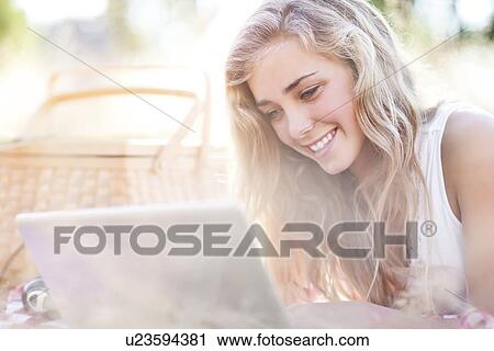 Happy teenage girl (16-17) using laptop outdoors View Large Photo Image Stock Image - Happy teenage girl (16-17) using laptop outdoors. Fotosearch