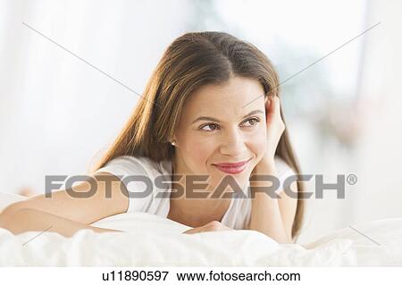 Happy woman lying on bed View Large Photo Image Stock Photo - Happy woman lying on bed. Fotosearch