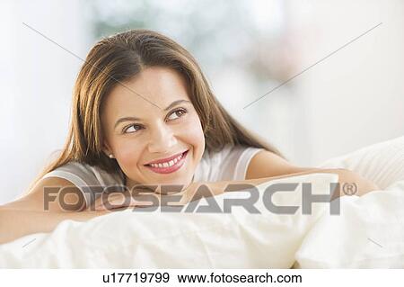 Happy woman lying on bed View Large Photo Image Stock Photo - Happy woman lying on bed. Fotosearch