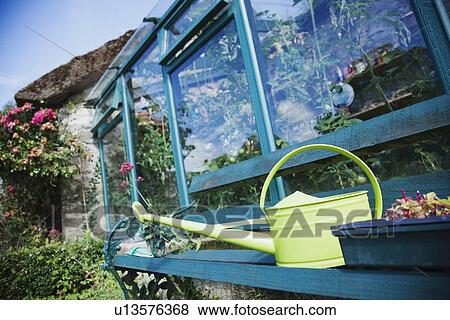 Ireland, County Westmeath, Watering can in front of greenhouse View Large Photo Image Stock Photo - Ireland, County Westmeath, Watering can in front of greenhouse. Fotosearch