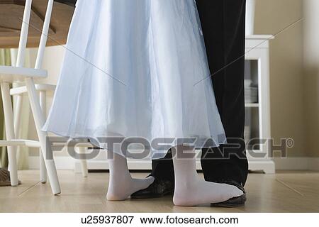 Stock Photo - Low section of Father and Daughter (10-11) dancing. Fotosearch