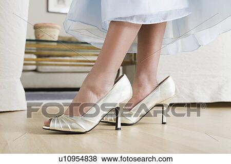 Low section of girl (10-11) wearing oversized shoes View Large Photo Image Stock Photo - Low section of girl (10-11) wearing oversized shoes. Fotosearch