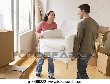 Man and woman carrying chair in new house View Large Photo Image Stock Image - Man and woman carrying chair in new house. Fotosearch